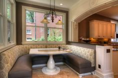 a kitchen with a banquet table in the middle and a corner bench at the end