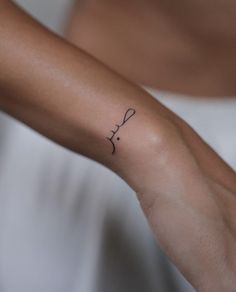 a woman's arm with a small tattoo on the left side of her wrist