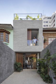 a dog is sitting in front of a house that has been built into the side of it