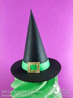 a black witches hat with a green square on the front and gold trim around it