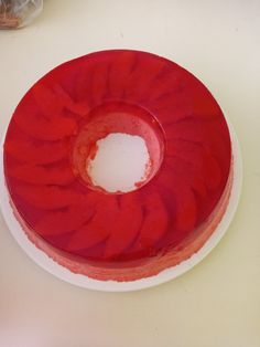 a red cake sitting on top of a white plate