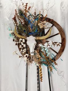 a steer's head is adorned with dried flowers and grasses