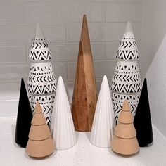 several black and white vases sitting on top of a counter next to a wooden cone