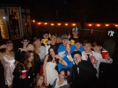 a group of people dressed in costumes posing for a photo at a party with drinks