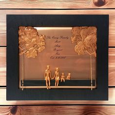 a glass frame with some gold figurines in it