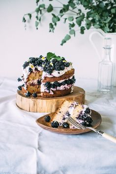 a piece of cake on a wooden plate with a fork next to it and a vase in the background