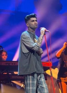 a man standing on top of a stage holding a microphone