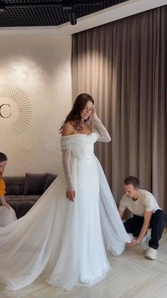 a woman in a white wedding dress standing next to a man