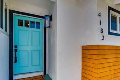 a blue front door on the side of a house