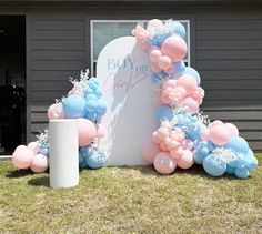 balloons and streamers are arranged in the shape of an arch