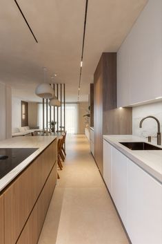 a long narrow kitchen with wooden cabinets and white counter tops