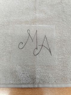 an embroidered monogrammed bath mat with the letter a and m on it in black ink