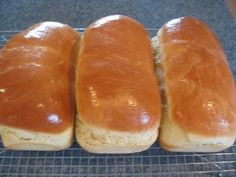 three long loafs of bread sitting on top of a cooling rack