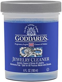 the jar of jewelry cleaner is blue with silver trimmings and an emblem on it