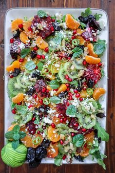 a white platter filled with fruit and veggies