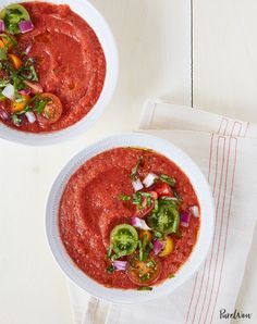 two white bowls filled with red sauce and veggies