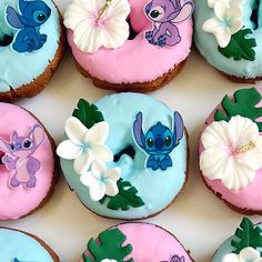 there are many decorated doughnuts in the box with fondant flowers on them