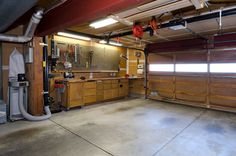 an empty garage with lots of wood cabinets