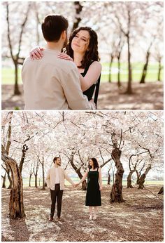 a man and woman holding hands in front of cherry blossom trees with their arms around each other