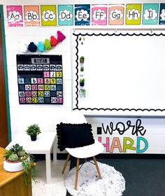 a classroom with white walls and colorful letters on the wall, along with a black chair