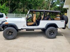 a white jeep parked in front of a house