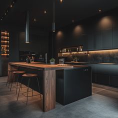 a kitchen with an island and bar stools in the center, surrounded by black cabinets