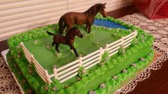 two cakes with horses on them sitting on a table next to a red basket and white doily