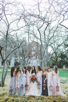 a group of women standing next to each other in front of some trees and grass