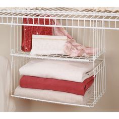 a white wire shelf holding towels and blankets