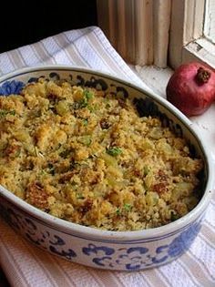 a casserole dish with stuffing in it next to an apple on a table