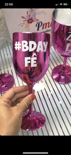 a person holding a wine glass with the words bday fe on it