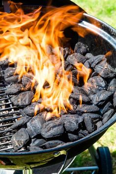 a close up of a grill with rocks on it's side and flames in the middle