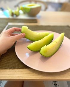 a person is sitting at a table with a plate of fruit in front of them