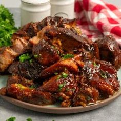 meat with sauce and parsley on a plate next to two bottles of dressings