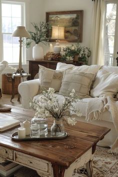 a living room filled with furniture and lots of white flowers on top of a coffee table