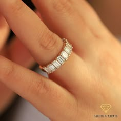 a woman's hand with a diamond ring on top of her finger, showing the band