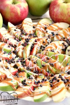 an apple pie with sprinkles and chocolate chips on top, surrounded by apples