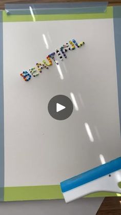 the word happy spelled out in letters on a piece of paper next to a paint roller