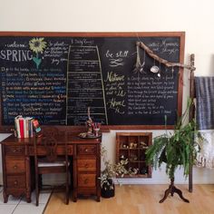 a blackboard with writing on it in a room next to a table and chair