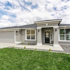 a house that is in the middle of a yard with grass and bushes around it