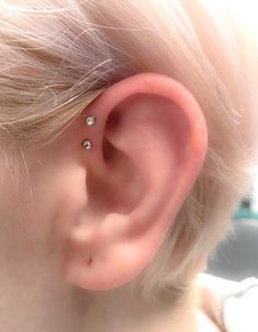 a close up of a child's ear with two piercings