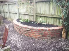 a brick wall in the middle of a garden