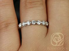 a woman's hand with a wedding ring on it and three stones in the middle