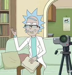 a person sitting on a couch with a camera in front of him and a bookcase behind them