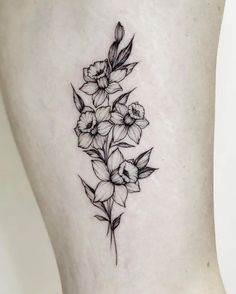 a black and white flower tattoo on the side of a woman's leg,