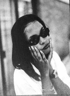 a woman wearing sunglasses and holding her hand to her face