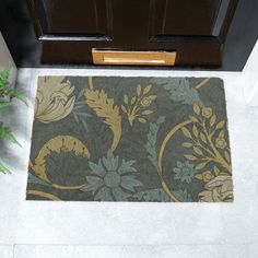 a door mat on the floor next to a potted plant