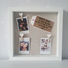 a white frame with some pictures hanging from it's sides and two hearts attached to them