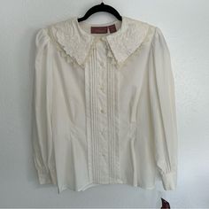 Open To Reasonable Offers!!! -Lace And Embroidery Detailing -Button Up -Fit And Flare -Shoulder Pads Size: 12 Color: White/ Cream Condition: New With Tags (Small Stain In Last Photo) Smoke And Pet Free Home Measurements Upon Request Vintage Lace Collar Button-up Top, Classic Cream Blouse With Ruffled Collar, Classic White Blouse For Vintage Fashion, Retro White Tops With Lace Trim, Classic Blouse With Ruffled Collar And Button Closure, Formal Blouse With Peter Pan Collar And Buttons, Classic Cream Blouse With Buttons, White Retro Top With Lace Collar, White Retro Top With Ruffled Collar