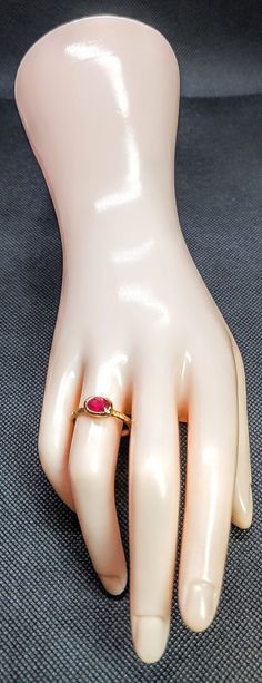 a hand with a ring on it sitting on top of a mannequin's head